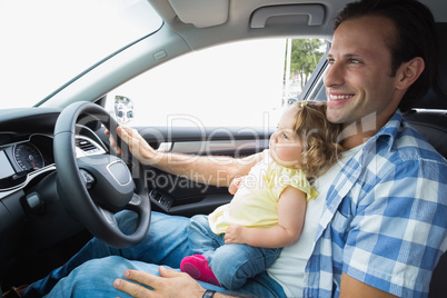 Father playing with baby in drivers seat