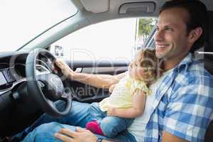 Father playing with baby in drivers seat