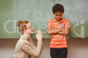Teacher apologizing boy in classroom