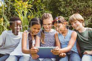 Children using digital tablet at park