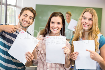 Portrait of happy students pointing at papers