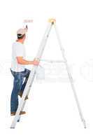 Handyman climbing ladder while using paint roller
