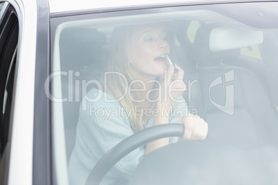 Young woman putting on makeup