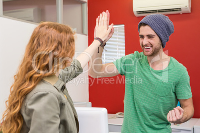 Casual businessman and woman high fiving