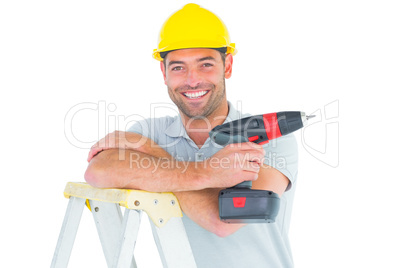 Male technician holding power drill on ladder