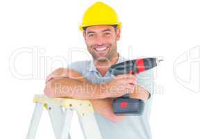 Male technician holding power drill on ladder