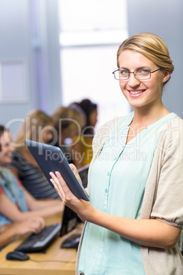 Teacher using digital tablet in computer class