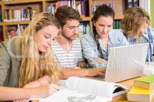 College students doing homework in library