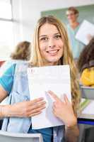 Beautiful female student pointing at paper