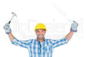 Smiling handyman holding hammer and level