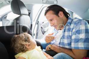 Father securing his baby in the car seat