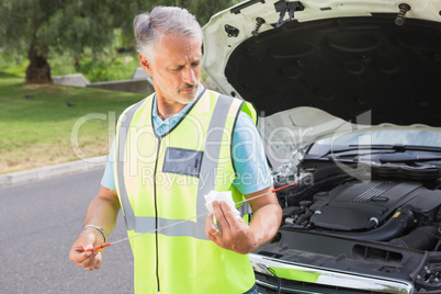 Man using dipstick to check oil