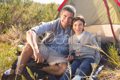 Father and son beside their tent in the countryside