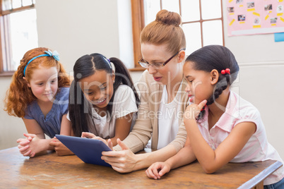 Teacher and pupils looking at tablet computer