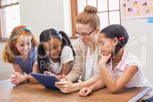 Teacher and pupils looking at tablet computer