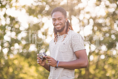 Handsome hipster using vintage camera