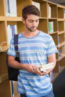 Student holding books in library