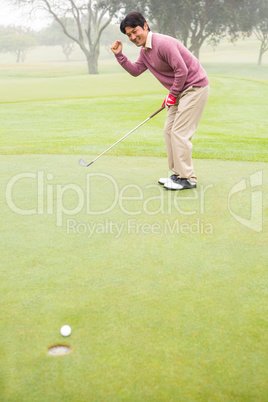 Happy golfer cheering on putting green