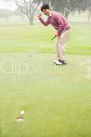 Happy golfer cheering on putting green