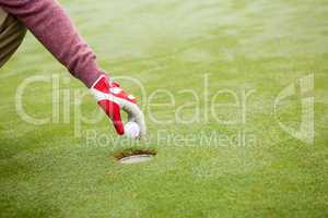 Golfer trying to flick ball into hole