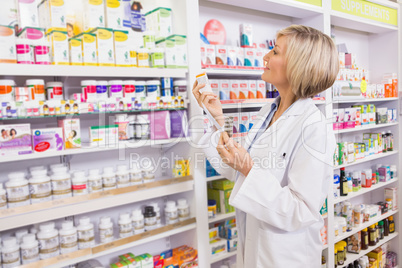 Smiling pharmacist holding prescription and medicine