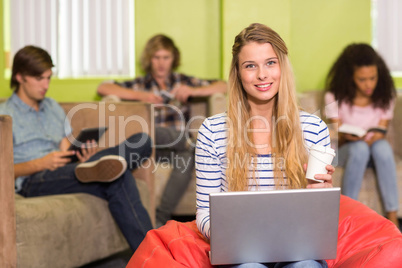 Casual young woman using laptop in office