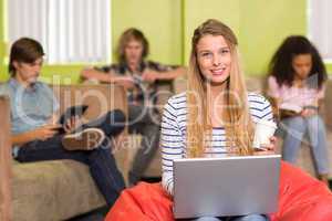 Casual young woman using laptop in office