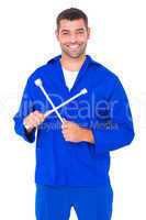 Smiling male mechanic holding lug wrench
