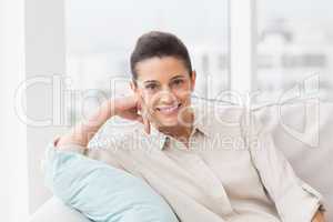 Portrait of happy woman relaxing on sofa