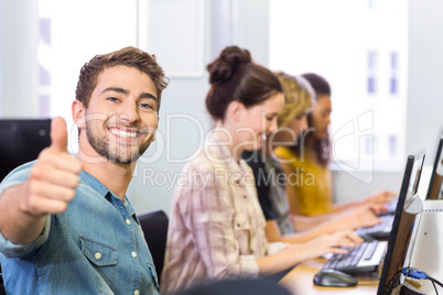 Student gesturing thumbs up in computer class