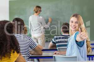 Female student gesturing thumbs up in class
