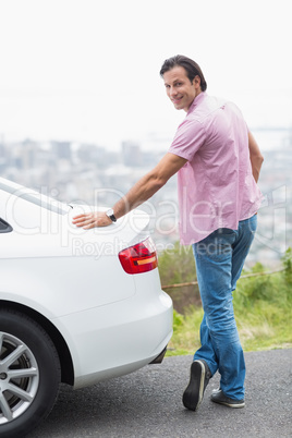 Smiling man standing next to his car