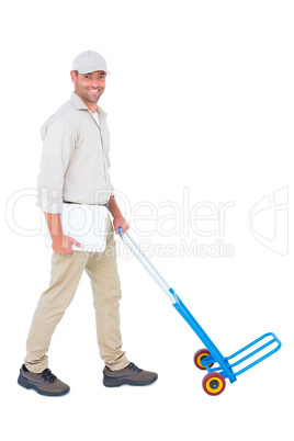 Confident delivery man pushing empty trolley