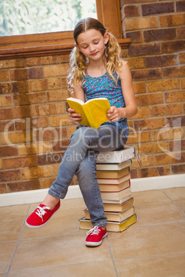 Cute little girl reading book in library