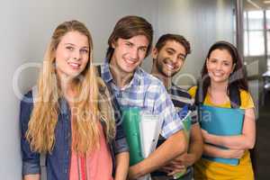 Students holding folders at college corridor