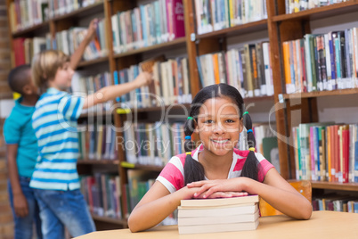 Cute pupils looking for books in library