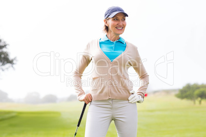 Female golfer standing with hand on hip