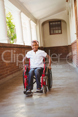 Girl sitting in wheelchair in school corridor