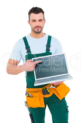 Smiling construction worker holding laptop