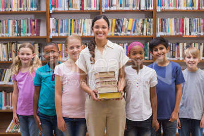 Cute pupils and teacher having class in library