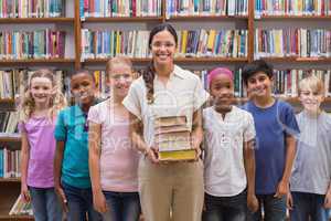 Cute pupils and teacher having class in library