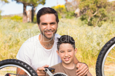 Father and son repairing bike together