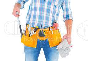 Midsection of handyman holding hammer and gloves