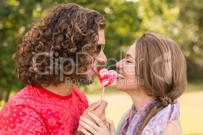 Cute couple sharing a lollipop