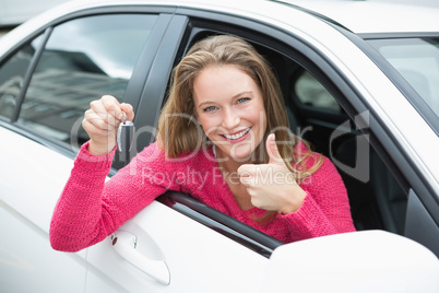 Young woman smiling and holding key