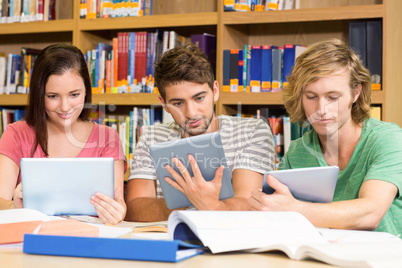 College students using digital tablets in library