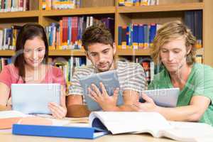 College students using digital tablets in library