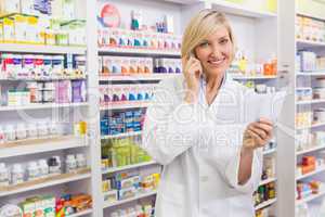 Smiling pharmacist on the phone reading prescription
