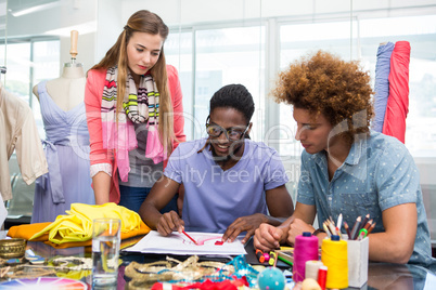 Team of fashion designers sketching