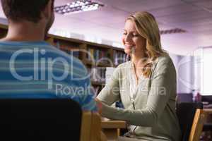 Student getting help from tutor in library